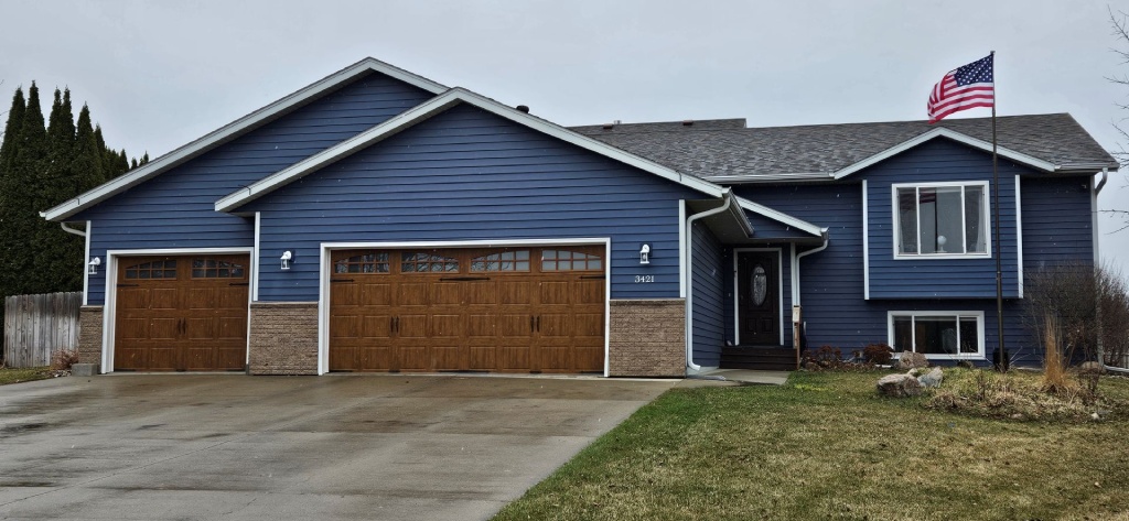 Home Split Level Blue Siding with Wood Garage Doors and Stone Accents.jpg